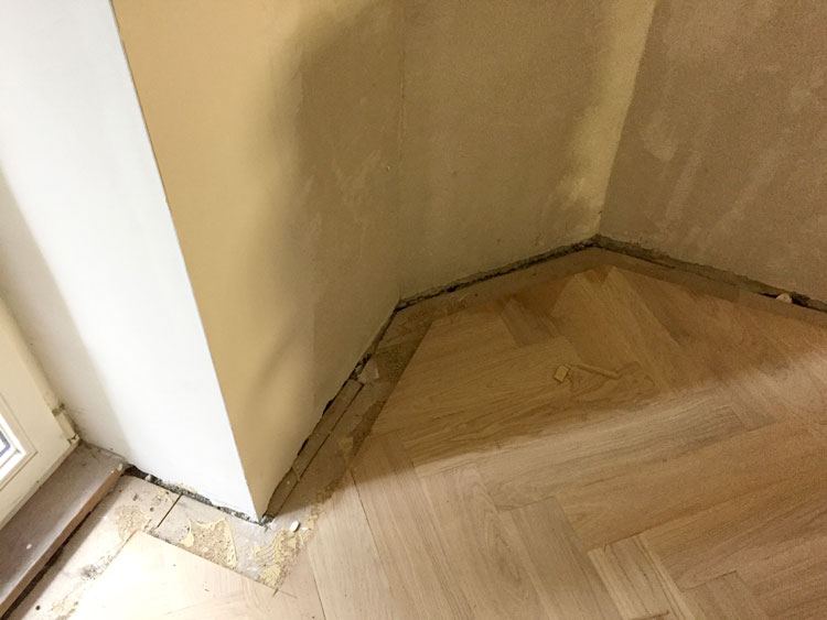 Fischgrätparkett mit Fries an einer Wandecke