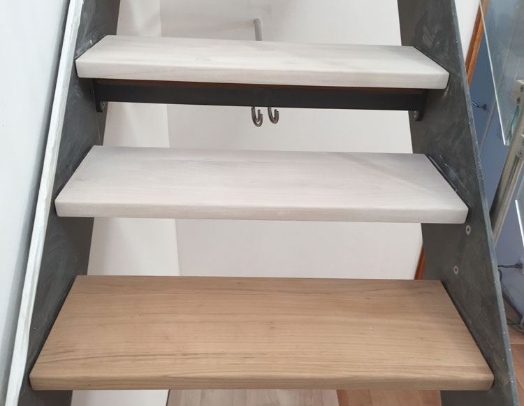 Offene Treppe mit hell lackierten und frisch geschliffenen Holzstufen