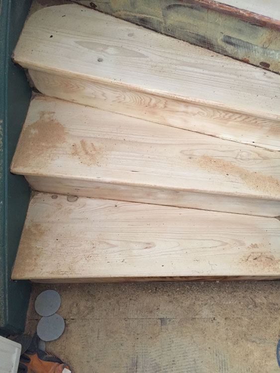 Frisch geschliffene Holzstufen einer gewendelten Treppe