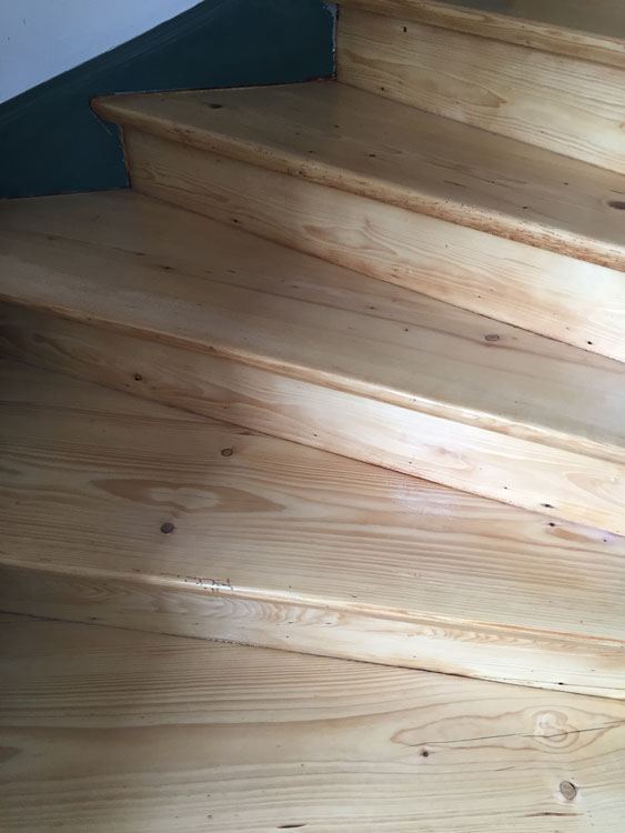 Hell geschliffene Stufen einer gewendelten Holztreppe