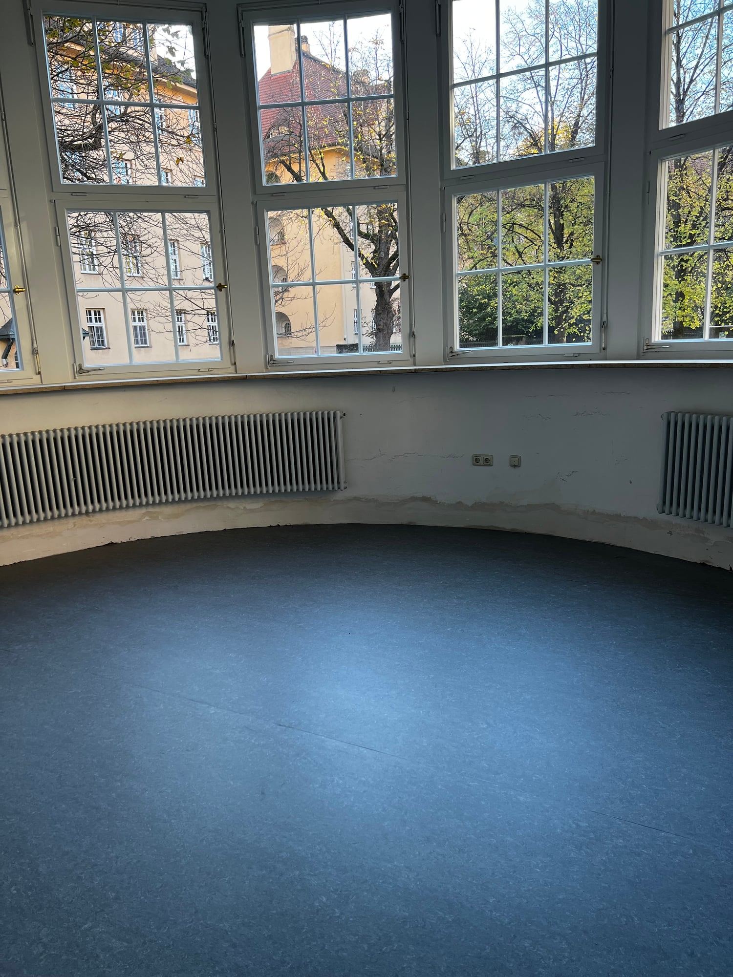 Blauer Linoleumboden in einem Raum mit halbrunder Fensterfront