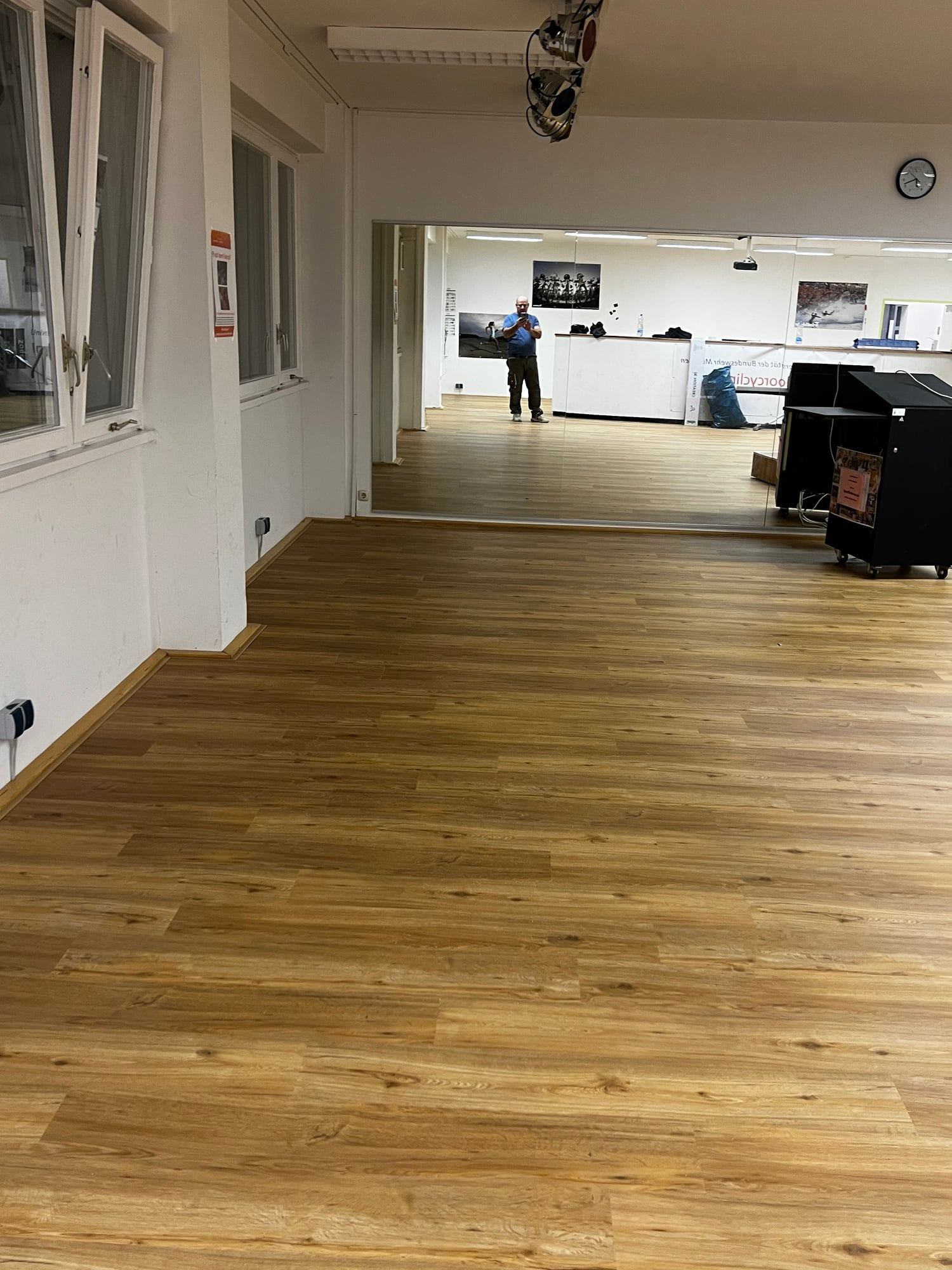 Großer Raum mit Vinylboden in Holzoptik und Fenstern auf einer Seite